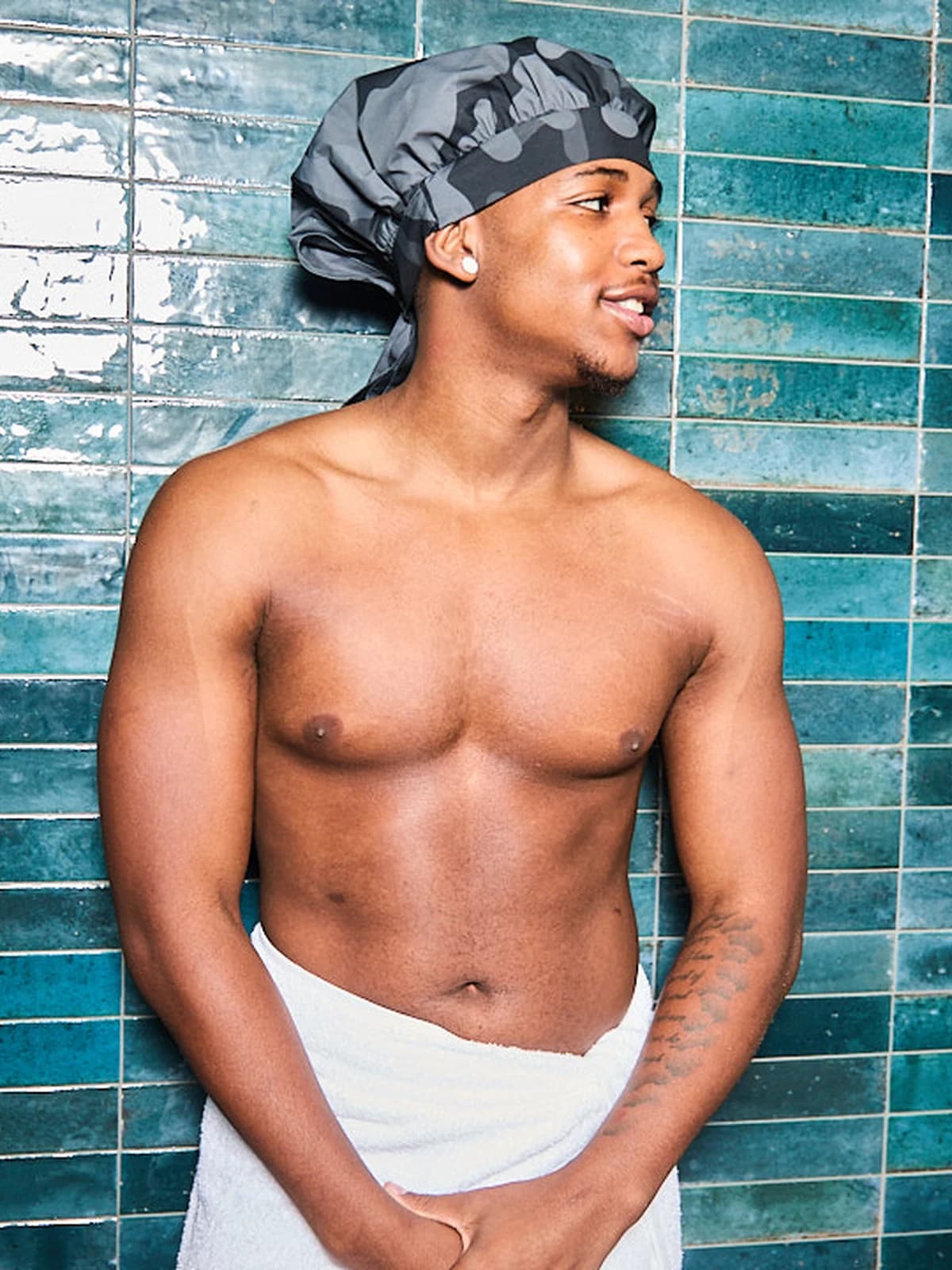 Model wearing a black camo Wrappd shower bonnet